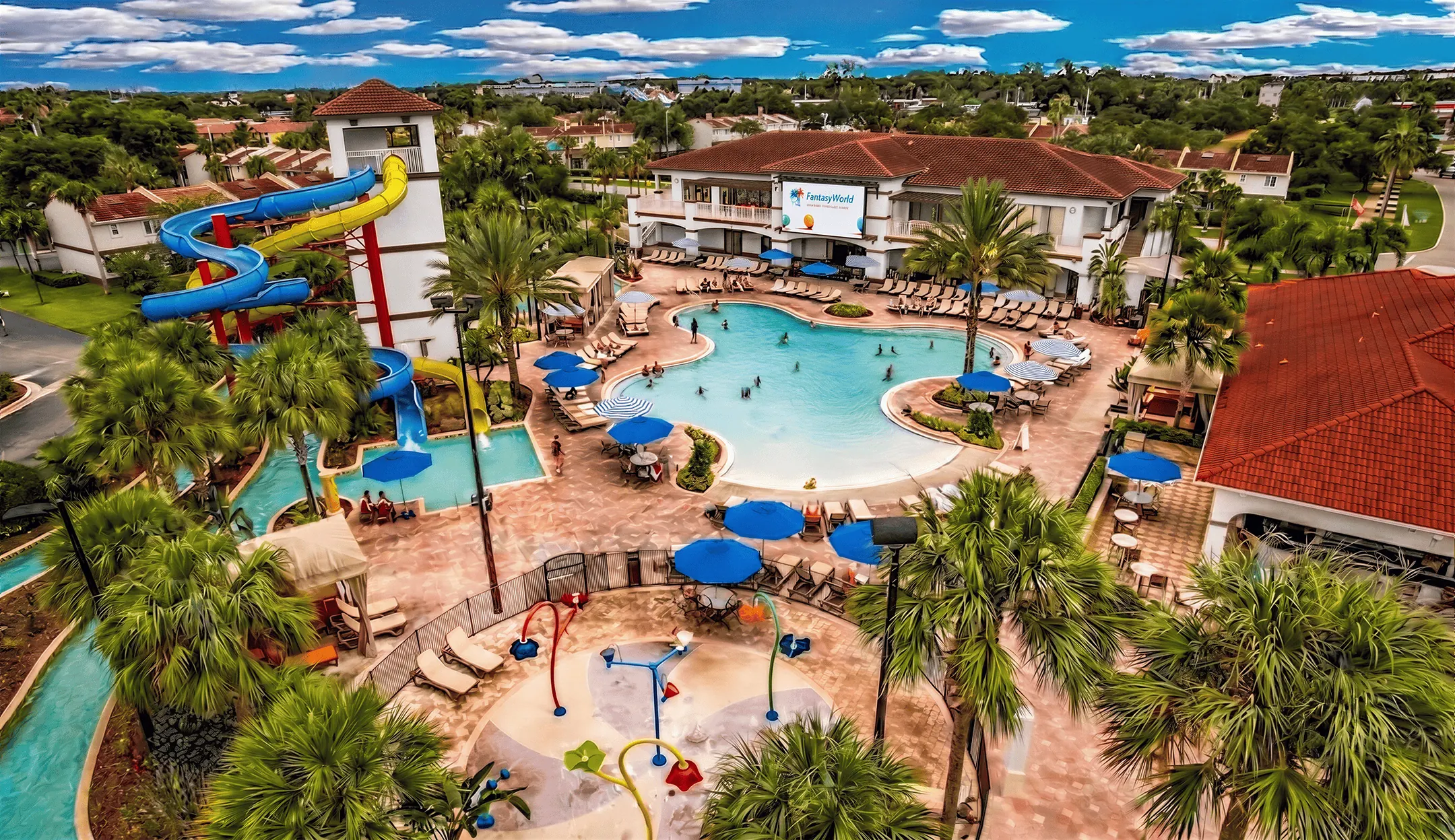 Aerial view of FantasyWorld resort with pool, slide tower, and splash pad