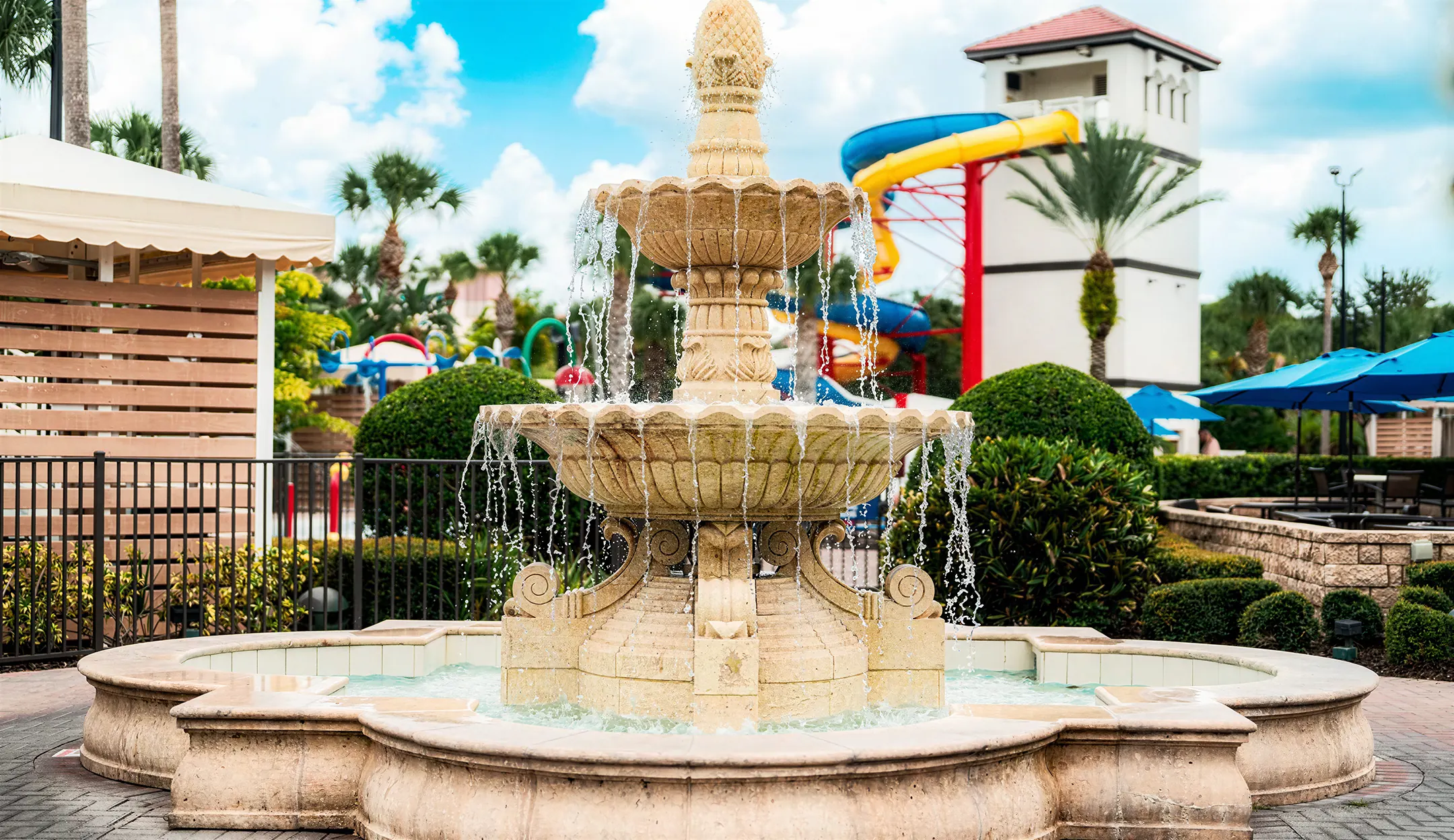 Tiered stone fountain with water slides rising in the background